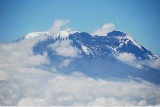 Use this image to answer the question. image of a snow covered mountain peak in africa.&lt;