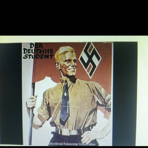 What belief system does the human in this figure in this poster represent?  a)fascism b)nazism c)com