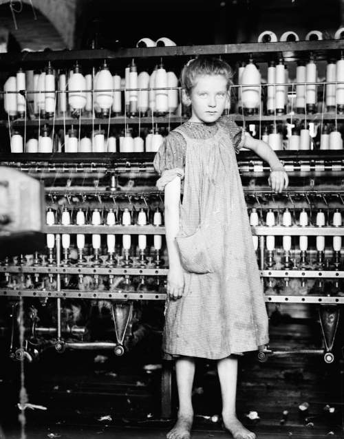 analyze this picture of a 12-year-old girl working in a mill. what safety hazards do you see