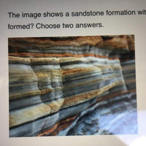 The image shows a sandstone formation with visible bands of different colors. what do the bands indi
