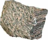Alayered metamorphic rock made of light and dark bands of minerals is  a. schist b. basalt c. gneiss