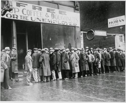 The photo shows men waiting in line for free bread and soup. Who was most likely responsible for buy