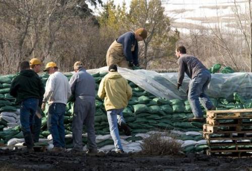 The image below shows people using sandbags as a means to contain a rapidly rising river. Which proc
