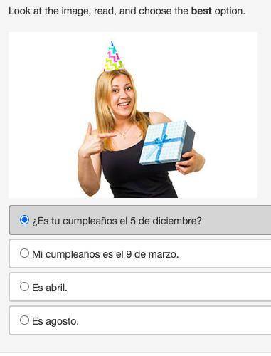 Look at the image, read, and choose the best option. A woman holding a birthday present and pointin