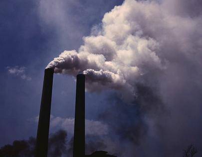 Examine the photo of a factory’s smokestacks. If new regulations were passed to prevent environment