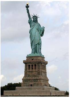 This photograph shows the Statue of Liberty.

A green statue of a woman holding a book in one arm